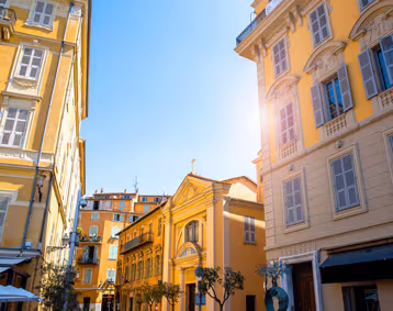 Sunlit city street with historic yellow buildings.