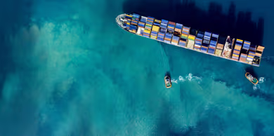 Aerial view of a container ship moving across open sea.